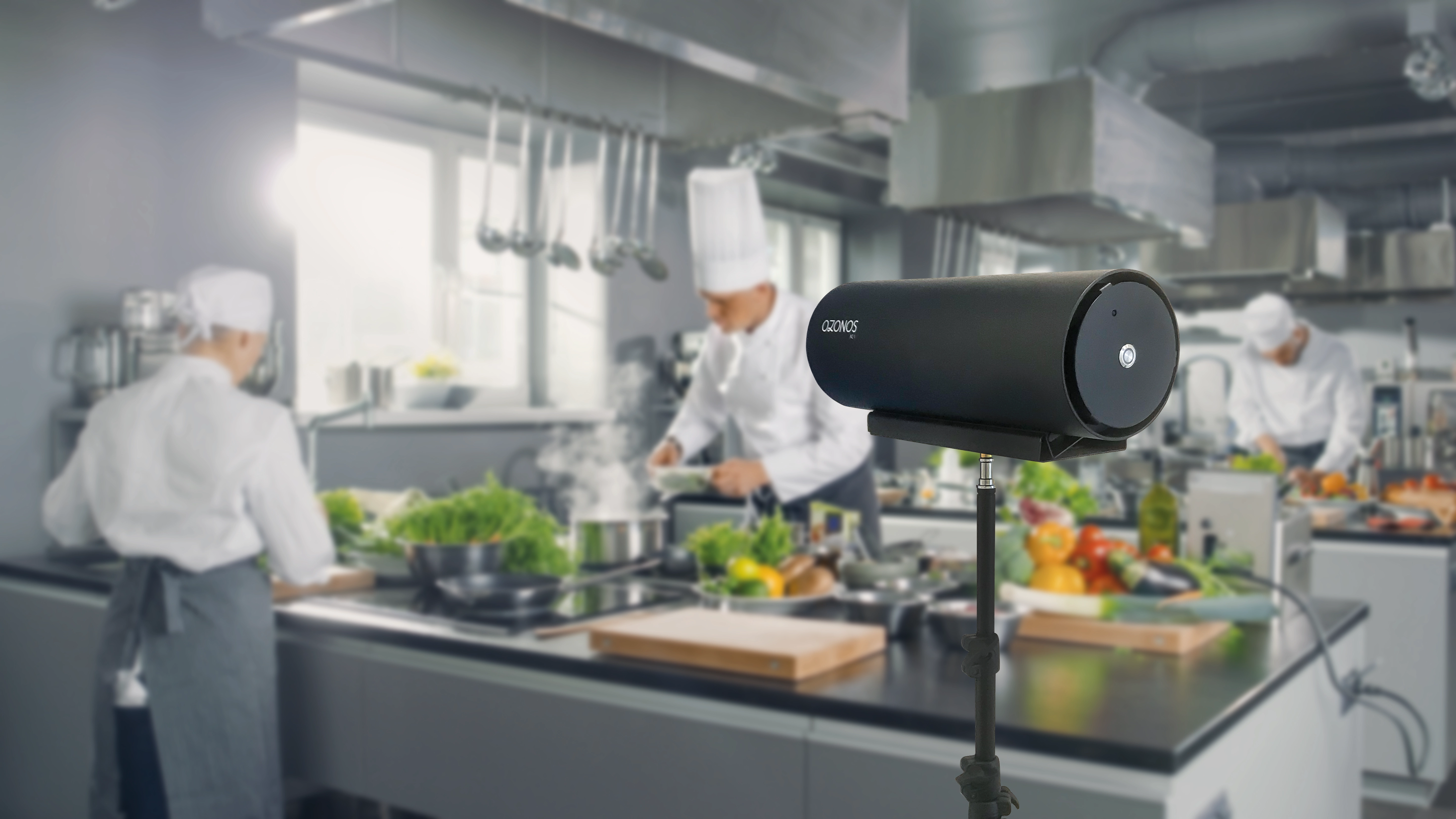 Black OZONOS air filter on the optional stand is cleaning the air of a restaurant kitchen